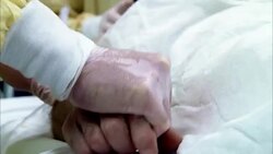 Closeup the latex gloved hand of a medical professional clasps the hand of a trauma patient. Stock Footage