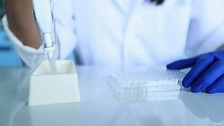 Scientist transfer mix small volume liquids within 96 well dishes, Slow motion Stock Footage