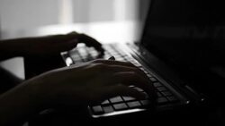Silhouette of female hands typing on a laptop Stock Footage