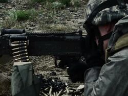 Soldier firing a belt-fed machine gun from a sitting position. Stock Footage