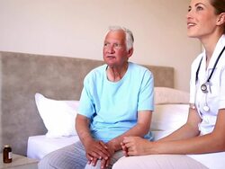 Home nurse speaking with elderly patient Stock Footage