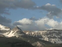 MS View of Clouds and Snow Rolling over Majestic Mountain Peaks in evening Light / Telluride, Colorado, United States Stock Footage
