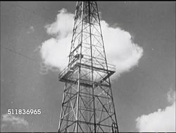 1947: USA OIL INDUSTRY: DRILLING: TU/TD Oil derrick, men working at base, driller checking gauges, CU Rotary rig drill turning. Instructional Video