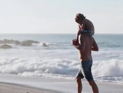 MS PAN Man walking on beach with boy on shoulders then takes boy off shoulders / Montezuma, Puntarenas, Costa Rica Stock Footage