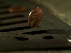 Money Down the Drain - High speed English coin, 1p falling, spins round to show Queen's head design, and falls in to road drain, low angle 5 BCU Stock Footage