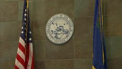 American and City of Las Vegas flags pillar a State of Nevada crest in a courtroom. Stock Footage