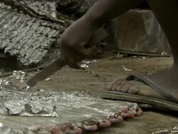 CU Shot of man sitting on railway line sorting through electric cable and men recovering copper pipe from old heat exchangers / Lagos, Nigeria Stock Footage