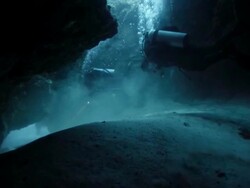 WS Divers swimming through cave in coral reef Stock Footage