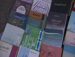 Pan right across selection of arabic books on a market stall, El Bizri, Egypt (sound available) Stock Footage