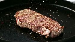 SLO MO Seasoning a pan fried beef steak Stock Footage