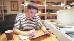 Attractive young female working or maybe studying in the coffee shop. Stock Footage