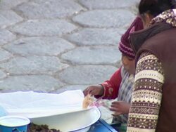CU of women and child setting up food cart, child tastes some and smiles, Cochabamba, Bolivia Stock Footage