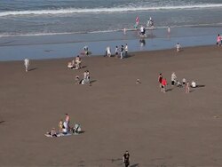 PEOPLE PLAYING IN SEA AND ON BEACH Stock Footage