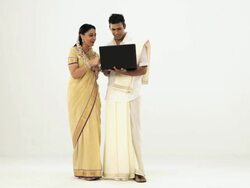 Portrait of a south Indian couple shopping from a laptop through credit card  Stock Footage