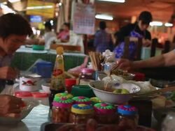 MS SLO MO POV Man and woman eating at small table in indoor market / Vientiane, Laos Stock Footage