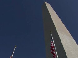 Low Angle pan-right - American flags surround the Washington Monument. / Washington, D.C., USA Stock Footage