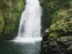 MS SLO MO Shot of waterfall pouring into hidden river canyon with lots of green moss / Hood River, Oregon, United States  Stock Footage