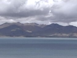 Pull back reveal Rakshastal Lake with dense clouds and mountains Lhasa Tibet China Stock Footage