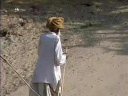 Old man walking with staff in India Stock Footage
