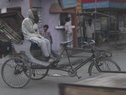 WS Cycle rickshaw driver having break and smoke at streetcorner / Patna, Bihar, India Stock Footage