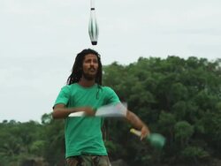 man with dreadlocks and a beard juggling on the beach Stock Footage