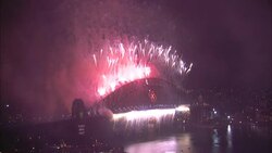 Pink fireworks explode over Sydney Harbor Bridge at night. Stock Footage