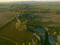 Low altitude forward POV of small creek with trees in full autumn colors near Bozeman, MT Stock Footage