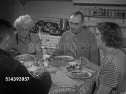 1953: UNION PACIFIC TRAIN DISPATCHER: WS Engine dispatcher James making telephone car. VS Engineer Arthur Franks at home at dinner table w/ family, answering ringing phone, talking to James about train schedule (SOT), James switching telephones. Instructional Video