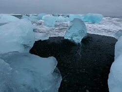 MS Ocean wave rolling in to washed glaciers on Jokulsa Iceberg Beach at mouth of Jokulsarlon / Iceland Stock Footage