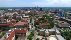 UT Tower Aerial Fly by Austin Texas Over University of Texas at Austin Capital Cities with Downtown Cityscape Skyline in the background at Center moving forwards Stock Footage
