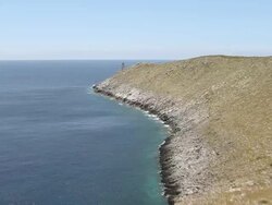 WS AERIAL View of Light house at coast of Peloponnese with flying to open water / Mani, Peloponnese, Greece Stock Footage