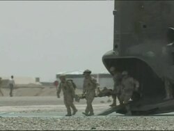 British Medical Emergency Response Team treat a wounded soldier on board a helicopter Stock Footage