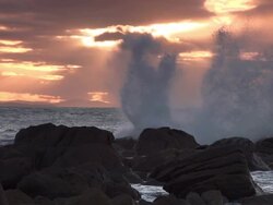 Wave crashing onto rocks at sunrise in slow motion. Stock Footage