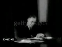 1937: ROOSEVELT AT DESK: President Franklin Delano Roosevelt (1882-1945) FDR sitting at desk looking at papers on desk, flipping page up to read other. Instructional Video