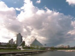 Long Shot pan-left tilt-down-Billowy clouds hover over skyscrapers by the Milwaukee Art Museum. / Milwaukee, WI Stock Footage