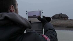 Young man taking photo of house with tablet in winter in rural Montana, USA. Stock Footage