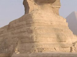 Medium, crane pan-right - The Great Sphinx sits in front of the Great Pyramids / Egypt Stock Footage