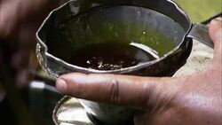 A mill worker pours oil through a funnel in an oil mill. Stock Footage