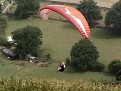 MS PAN SLO MO Shot of paraglider flying above hill tops Stock Footage