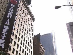 A sign on a high-rise building advertises that Bigger is better. Stock Footage