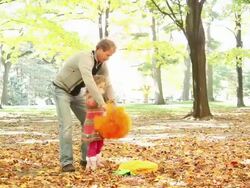 MS Father and little girls both of them dancing amid fallen leaves as little boy runs around / Toronto, Ontario, Canada Stock Footage