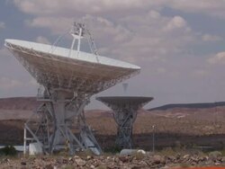 Wide Shot static _ Shadows crawl over two radio telescope dishes / Fort Irwin, California, USA Stock Footage
