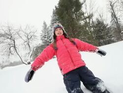 WS Girl creating snow angel during snowstorm / Yarmouth, Maine, USA Stock Footage
