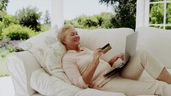 Happy senior woman shopping online on patio sofa Stock Footage