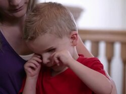 Medium shot of woman holding a blind child in her lap. Stock Footage