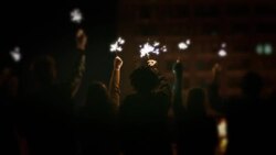 A group of young adults hold sparklers in the air. Stock Footage