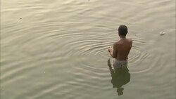 A young man washes in a river in India. Stock Footage