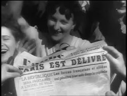 B/W 1944 close up excited French people holding up newspaper with headline 'Paris est delivre' at Liberation Stock Footage