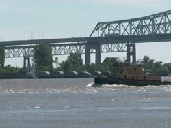 Wide Shot Zoom Out - Boat passing under bridge  / New Orleans Louisiana Stock Footage