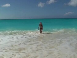 Young woman walking from thè ocean to the beach Stock Footage